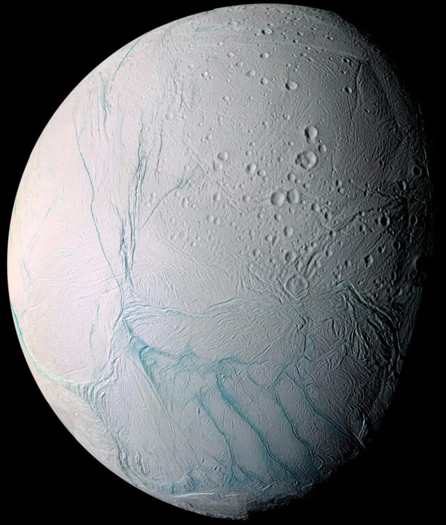 Figura 7. Encelado a colori, fotografato dalla camera della sonda NASA/ESA/ASI Cassini nel luglio 2005. In questa immagine, si nota la dicotomia tra l’emisfero nord, intensamente craterizzato e l’emisfero sud, con le freschissime “tiger stripes”, lineamenti blu dai quali è stata osservata l’emissione di geyser. Crediti: NASA/JPL/Space Science Institute.